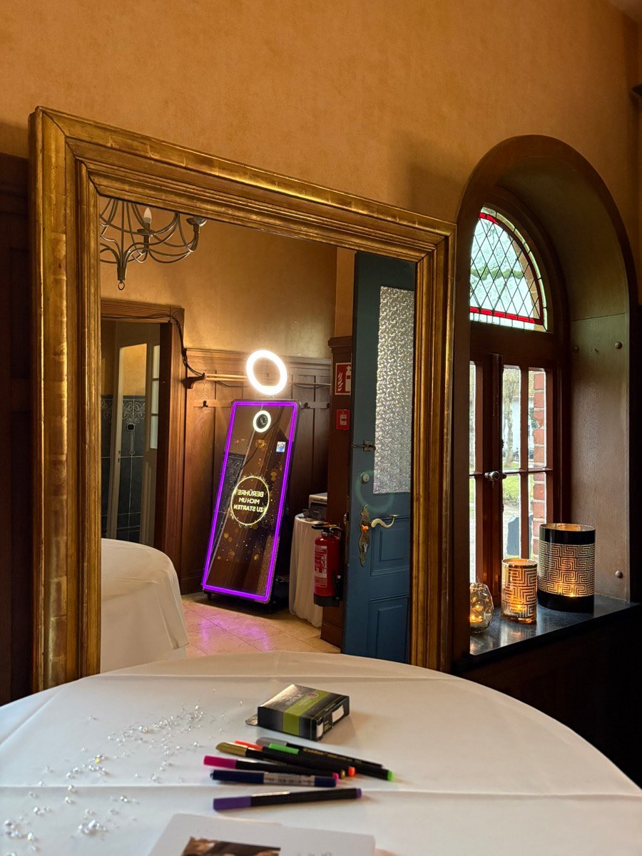 Blick durch einen goldenen Rahmen auf den Magic Mirror bei einer Feier in Lüneburg