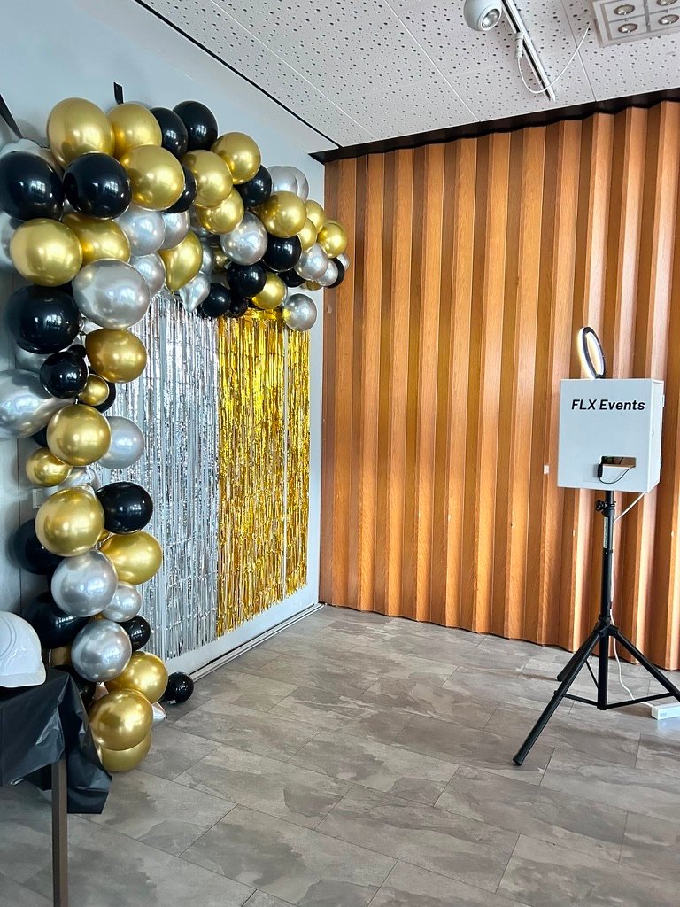 Fotobox Classic neben einer Fotowand mit Ballonbogen in Schwarz, Gold und Silber bei einem 18. Geburtstag in Wolfsburg